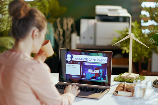 A woman using her laptop to use an AI image generator.