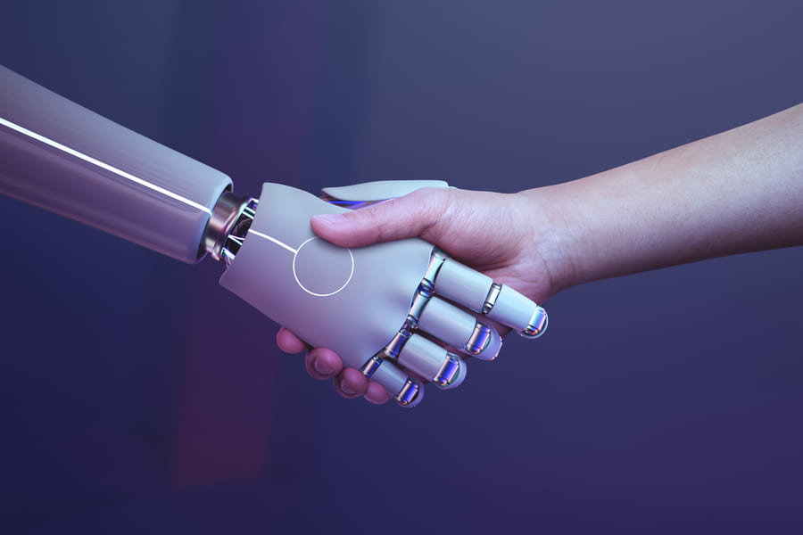 hunman and robot hands shaking each other